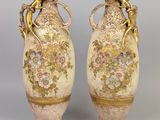 une paire de vases anciens ornés de motifs floraux sur fond gris