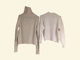 two white sweaters hanging on a clothes rack on a white background