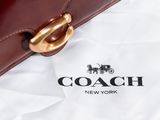 a coach bag with a horse and carriage logo on it