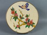 une assiette sur laquelle sont peints un oiseau et des fleurs