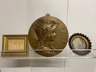a glass shelf with a gold medal and a clock on it