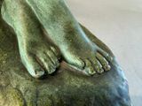 a statue of a person ' s feet on a rock