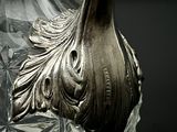 a silver vase that is sitting on top of a glass table