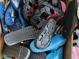 plusieurs paires de chaussures dans une boîte en carton posée sur le sol