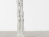 a white sculpture of a woman holding her hands up in the air