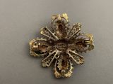 an image of a gold broochle with a cross on it