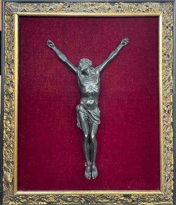 an antique bronze crucifix on a red velvet background