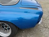 a close up of a blue car parked in a lot