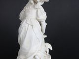 a white statue of a woman with a dog on a black background