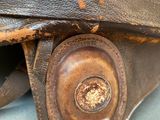 a close up of a brown leather bag on a blue surface