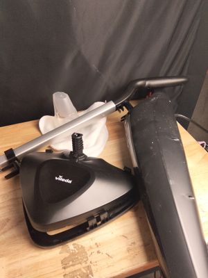 un aspirateur noir et argent posé sur une table en bois