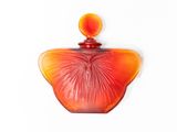 a red glass perfume bottle on a white surface