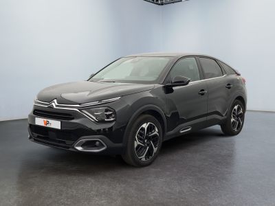 une voiture noire garée dans une pièce au sol noir
