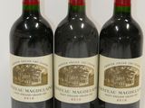 three bottles of red wine are lined up on a white surface