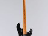 une guitare basse électrique suspendue à un fil fixé au mur