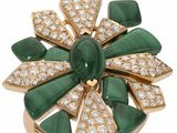 un gros plan d'une bague verte et blanche sertie de diamants
