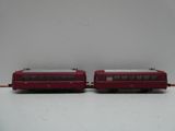 deux wagons rouges posés sur une surface blanche
