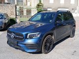 a blue mercedes suv parked on the side of the road