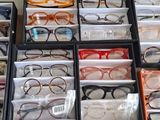 many boxes of glasses on a table with a person standing in front of them