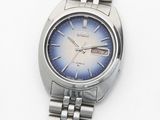 une montre en argent avec un cadran bleu sur un fond blanc