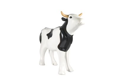 une figurine représentant une vache blanche et noire sur fond blanc