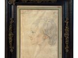 an antique portrait of a woman in profile in a black frame