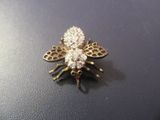 une broche en forme d'abeille en or et diamants sur un fond noir
