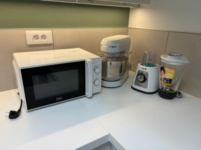 un micro-ondes et un mixeur posés sur le plan de travail de la cuisine