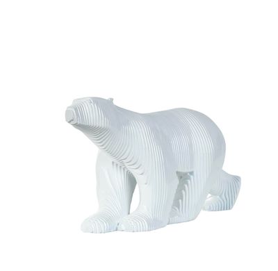 une figurine d'ours polaire blanc posée sur une surface blanche