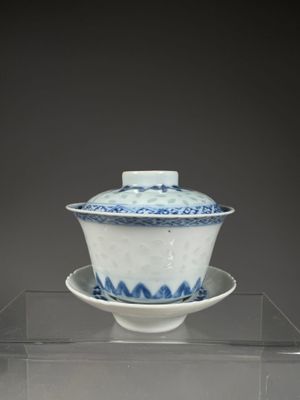 un bol et une soucoupe en porcelaine bleue et blanche posés sur une étagère transparente
