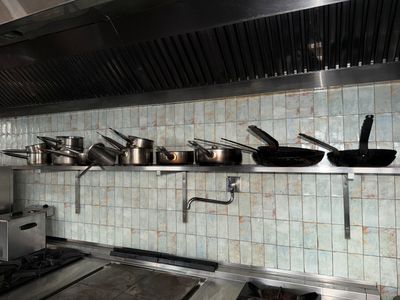 de nombreuses casseroles et poêles sur l'étagère de la cuisine