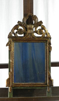 un miroir posé sur une étagère devant une fenêtre