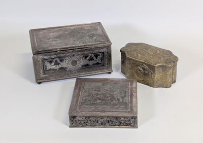 trois petites boîtes métalliques posées les unes à côté des autres sur une surface blanche