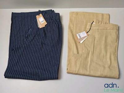 deux pantalons pour homme, avec une étiquette, posés sur une table