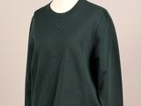 Ce pull est vert ; il a un col en V, des manches longues et une fermeture à boutons.