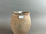 a small vase with a tag on it sitting on a table