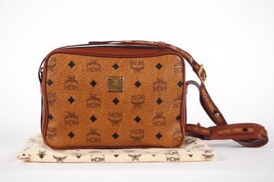a brown cross body bag sitting on top of a white surface
