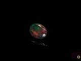 a black oplite with red and green speckles on it
