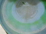 a green and white bowl sitting on a table
