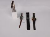 two watches and a watch stand on a white surface