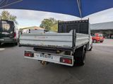 a white truck that is parked under a blue umbrella