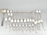 a lot of silver spoons and spoons laid out on a table