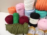 many balls of yarn sitting on a table next to each other