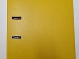 a close up of a yellow binder on a white surface