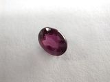 a close up view of a ruby colored stone on a white surface