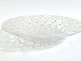 un bol en verre posé sur une surface blanche