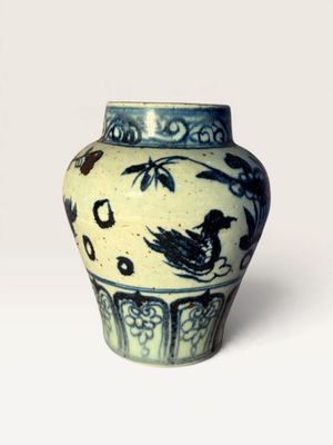 a blue and white vase with a bird on it