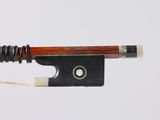 an old violin bow with a string attached to it on a white surface