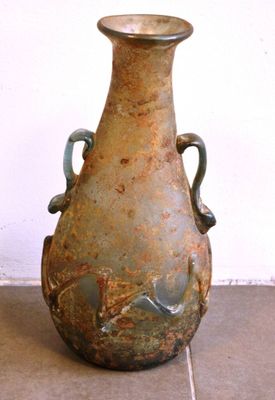 un vase posé par terre devant un mur