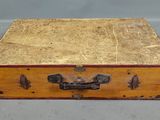 une petite boîte en bois munie d'une poignée en métal, posée sur une table